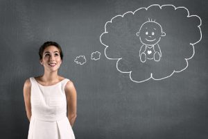 New Mother Holds Newborn Baby in Pink Fuzzy Blanket As Baby Sleeps Cuddled to Her Mother's Chest